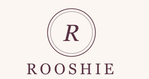 A minimalist logo graphic featuring a double-lined circle with a serif letter 'R' inside, above the word 'ROOSHIE' in dark plum text on a warm cream background with rounded corners.